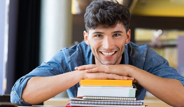 Man leaning on stack of books