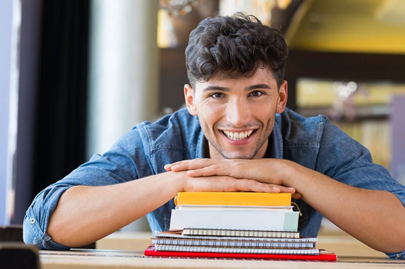 Man leaning on stack of books