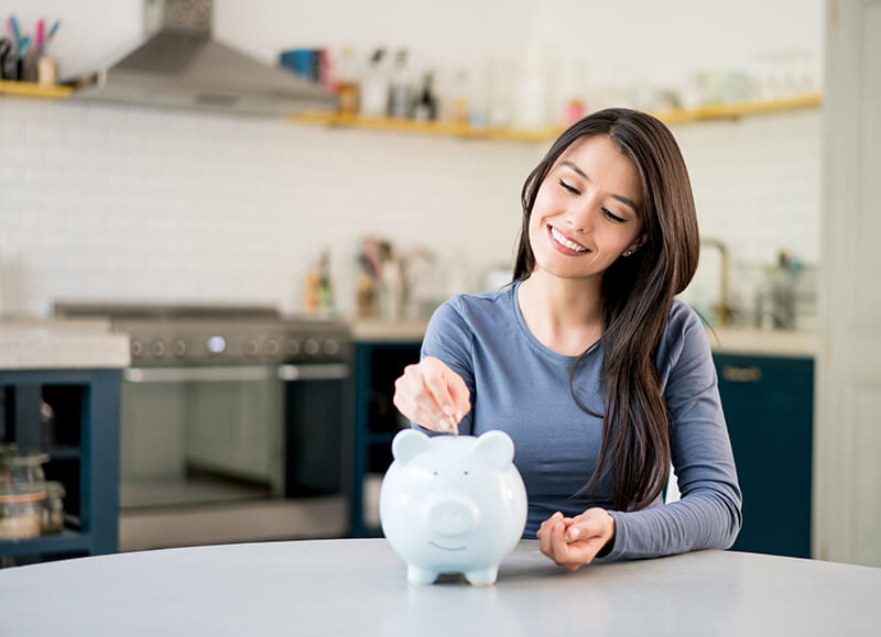 Female student saving money in a piggy bank