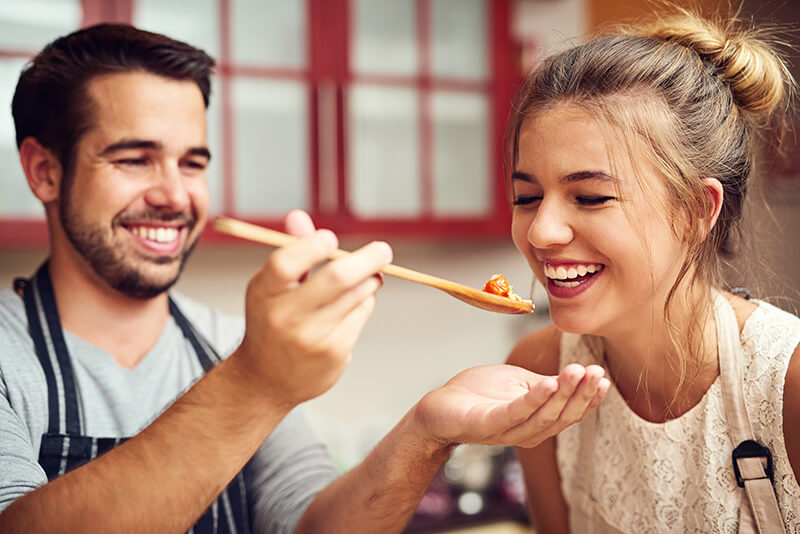 College students having fun cooking dinner