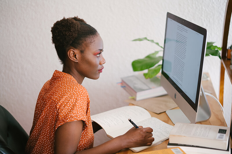 College student using computer to look up how to write a thesis statement