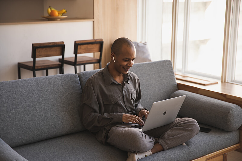Student listening to study materials on the couch