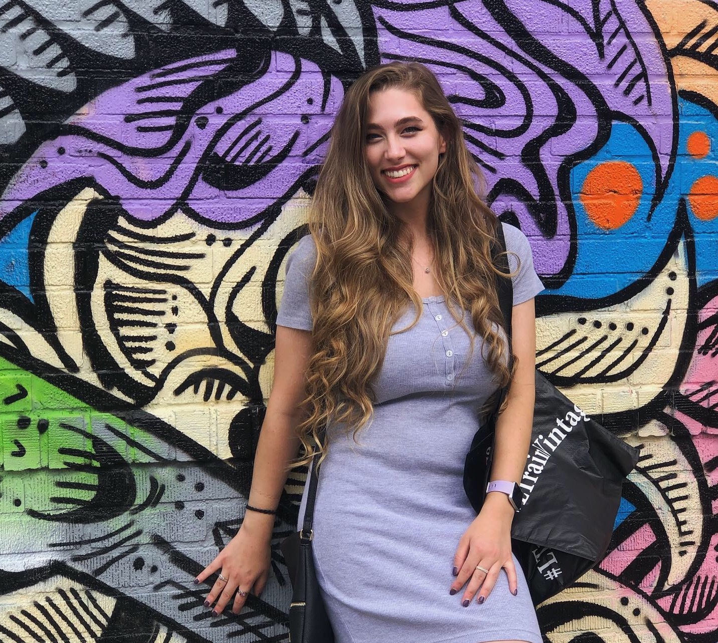 Alexis poses against a colourful wall mural in Atlanta, Georgia