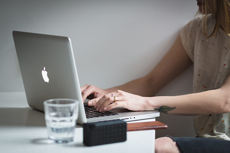 College student writing out different essay topics on a laptop