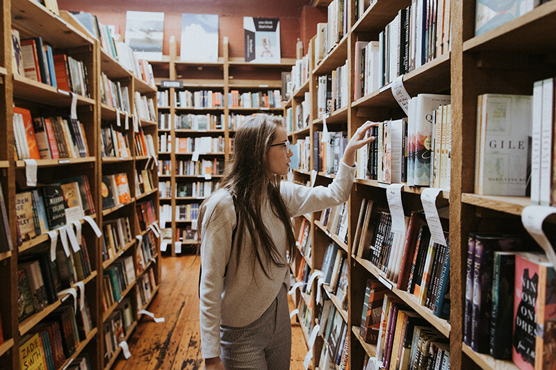 Female student trying to find research topics for college students in the library