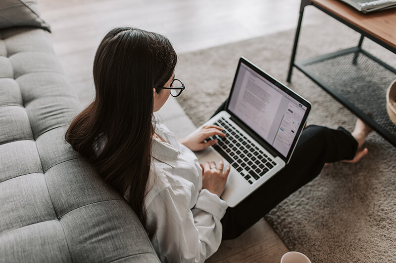 Student sitting on the floor writing essay transitions 