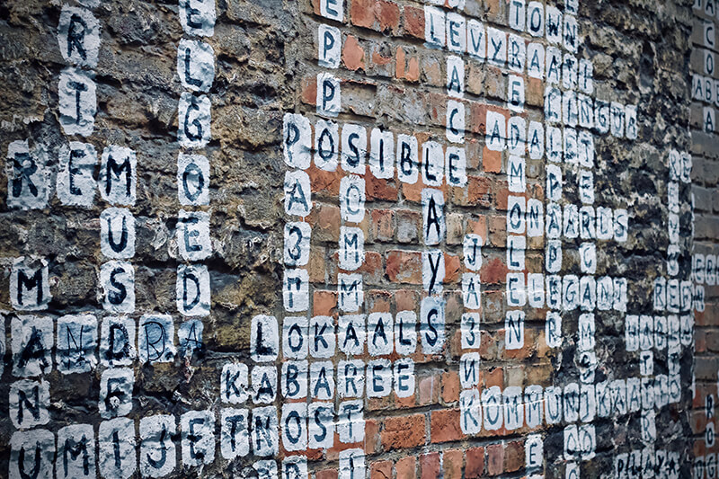 Brick wall with words being used to make different types of sentences
