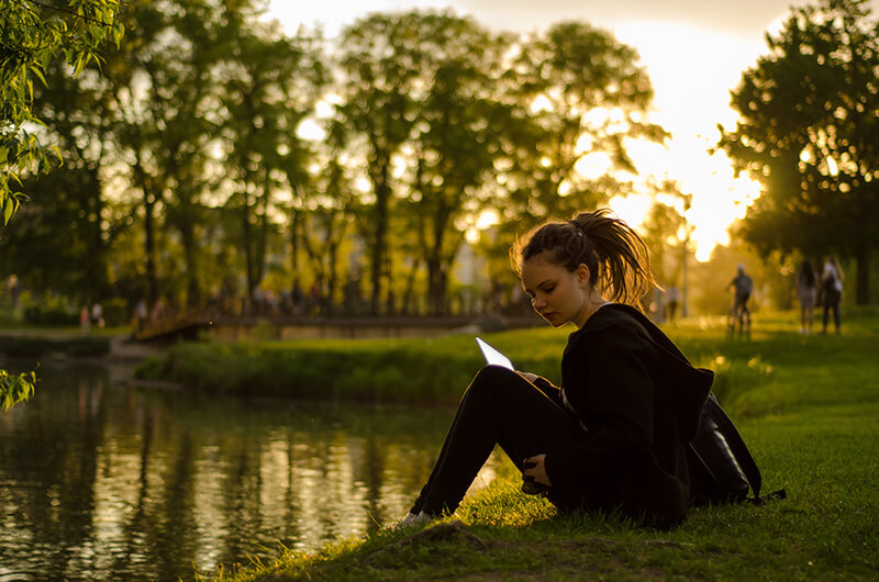 Female college student sitting outside trying to gather her personal opinions and thoughts