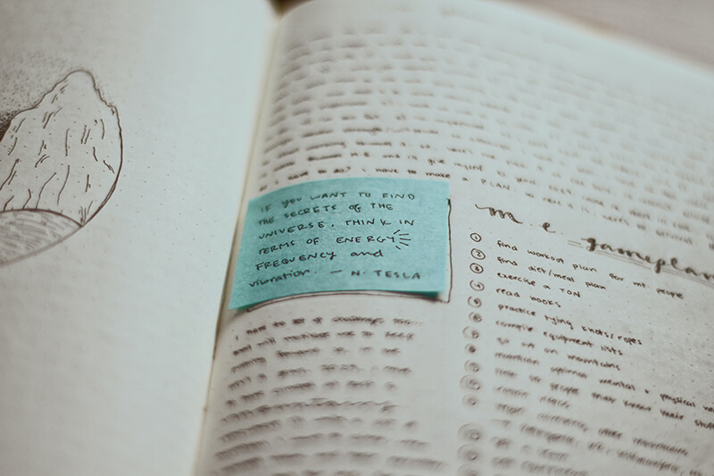 Book open to a page with a post it to record English grammar notes