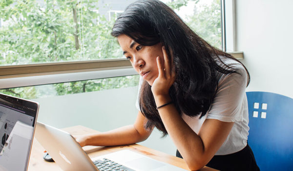 College student sitting at a computer learning how to write a reflection paper