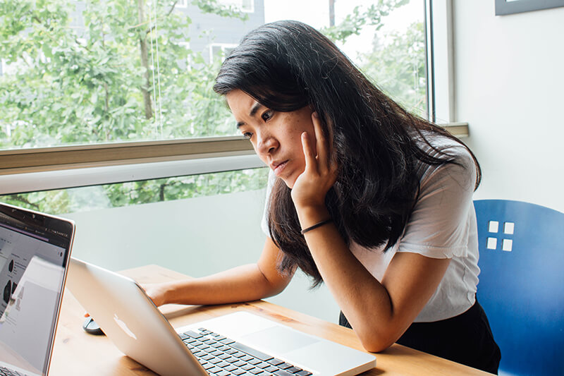 College student sitting at a computer learning how to write a reflection paper