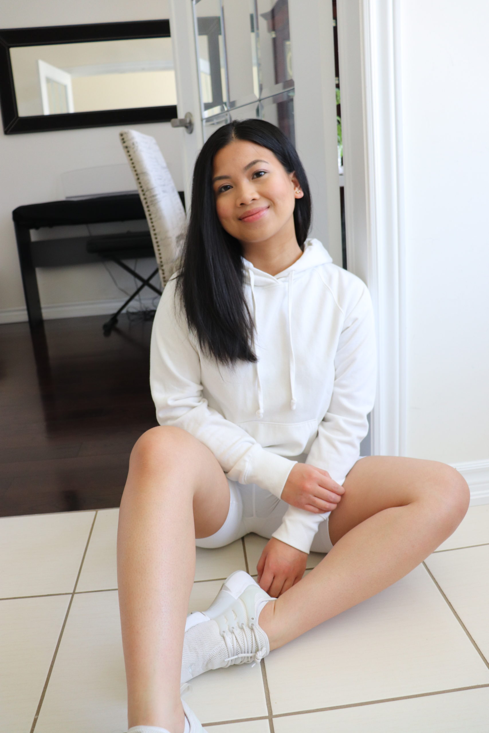Recent graduate Nathalee Pauline poses on the floor in her Toronto, Ontario apartment