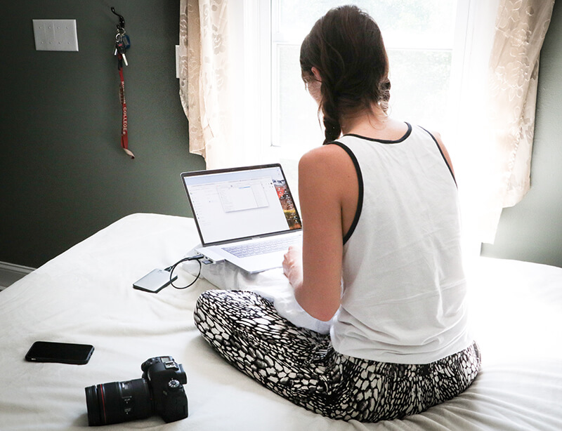 Young woman working on her essays with her back turned to the camera