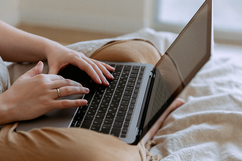 Woman looking at transition words for essays on her laptop