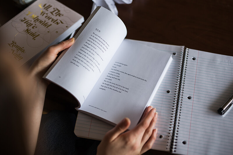 Female college student highlighting precis notes in her poetry book