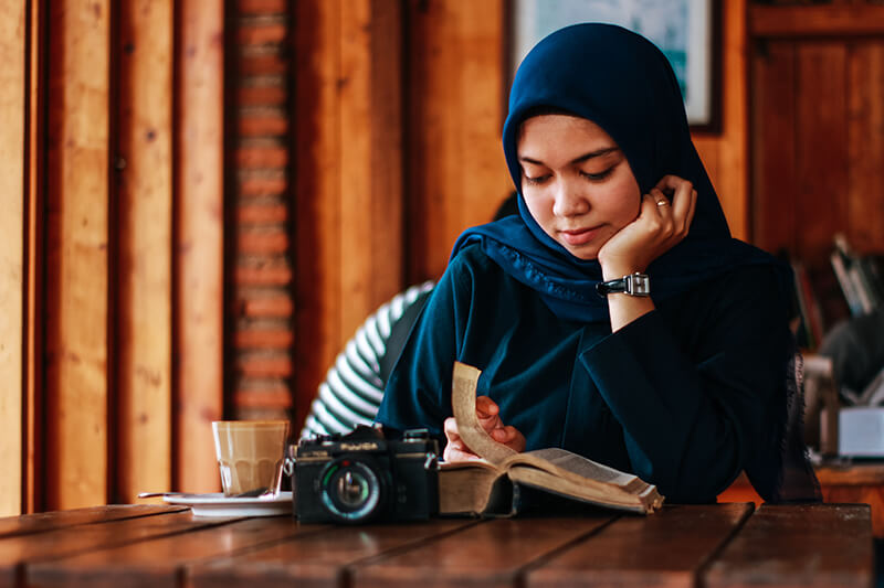 Female student choosing a story to use for her essay