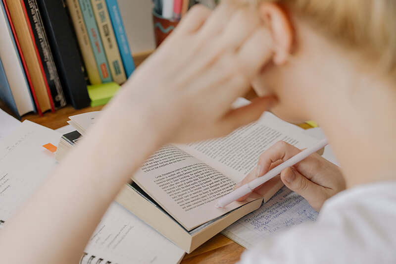 Male college student at a desk working on his thesis statement