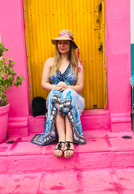 While volunteering abroad Egle Jakuciunaite sits outside on a colourful doorstep