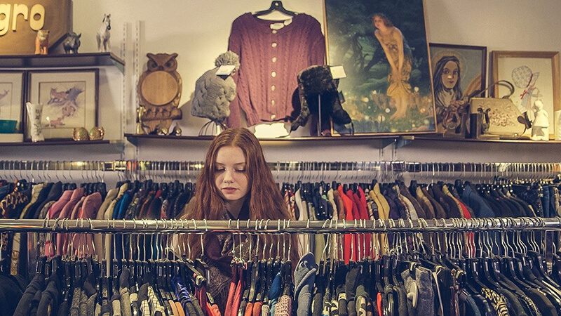 Young college student working on her shopping habits in a thrift store