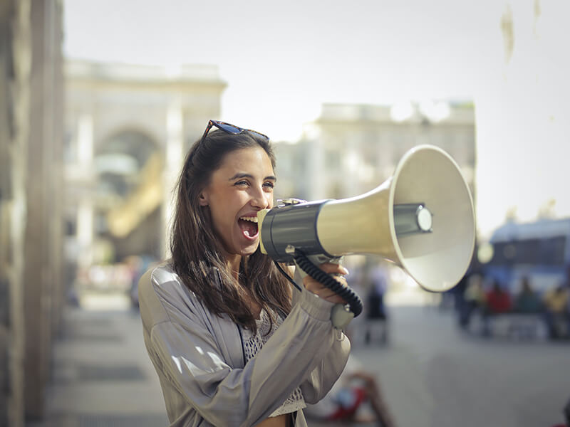 Female college student learning how to improve your public speaking by presenting a speech outside