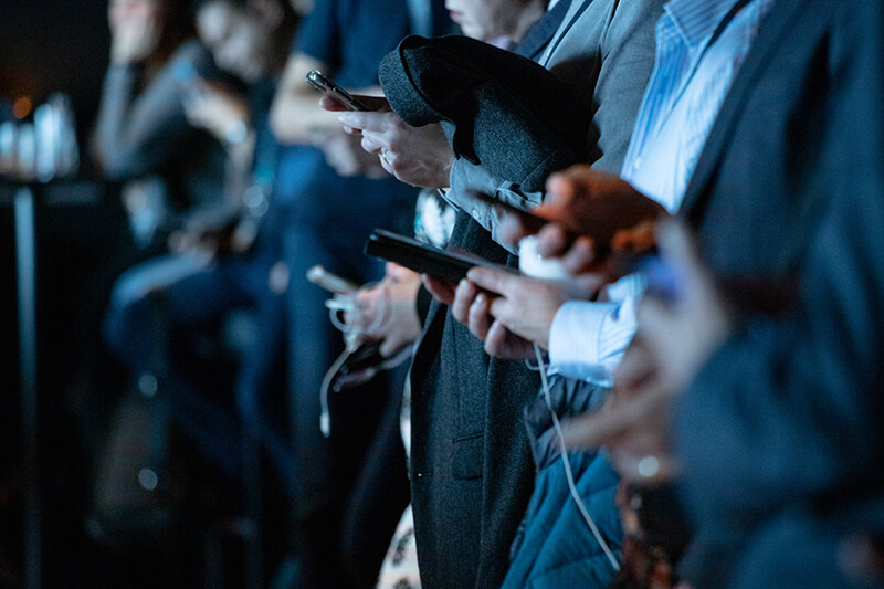 A row of teenagers busy checking social media on their phones