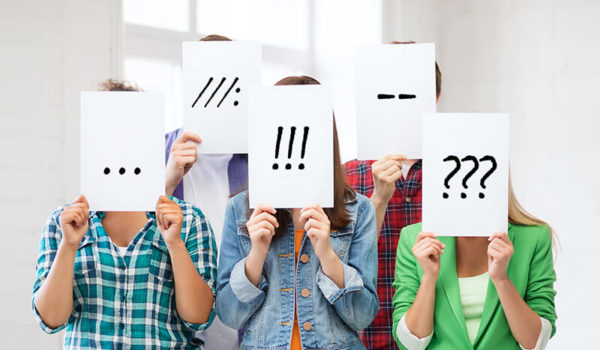 Group of students holding up signs with punctuation marks