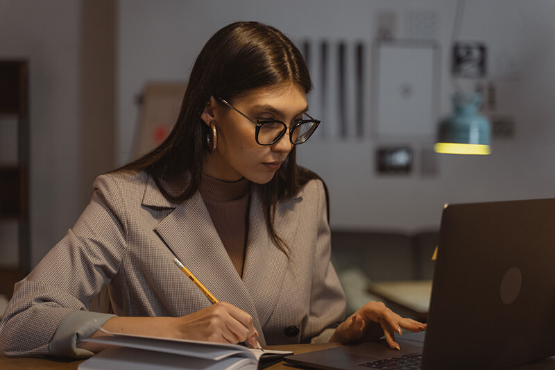 Female business woman using written notes to create a professional follow-up email