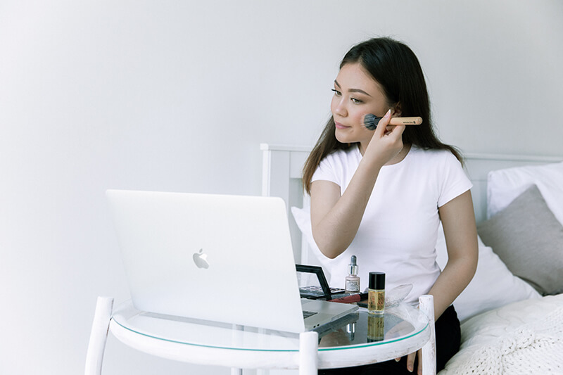 Female student working on her wellbeing with a makeup tutorial