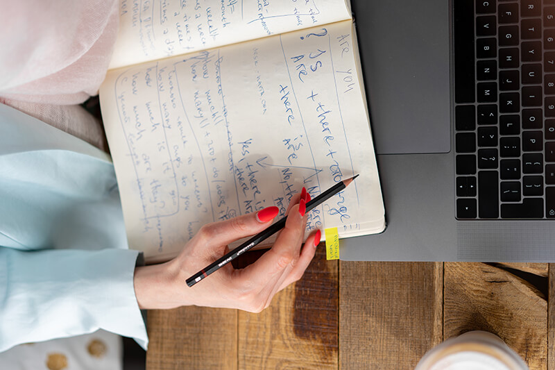 Young job applicant using paper to write out notes for a follow-up email