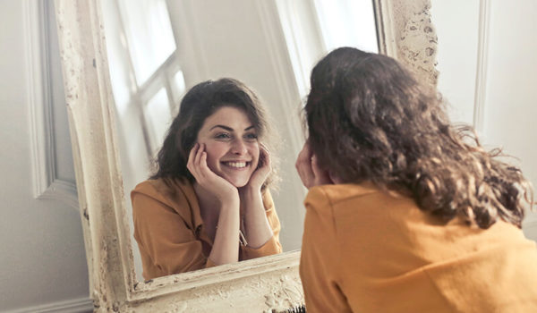 Young college student repeating positive affirmations in the mirror