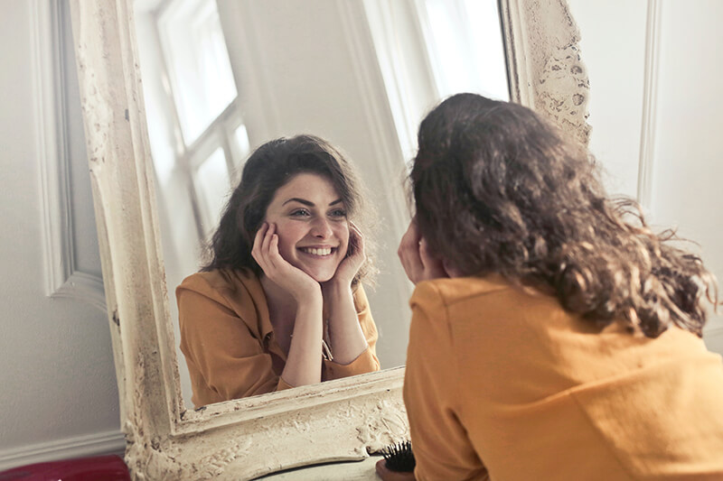 Young college student repeating positive affirmations in the mirror