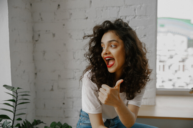 Female student expressing positivity through a thumbs up gesture