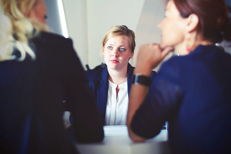 Two hiring managers interviewing a female candidate for a job