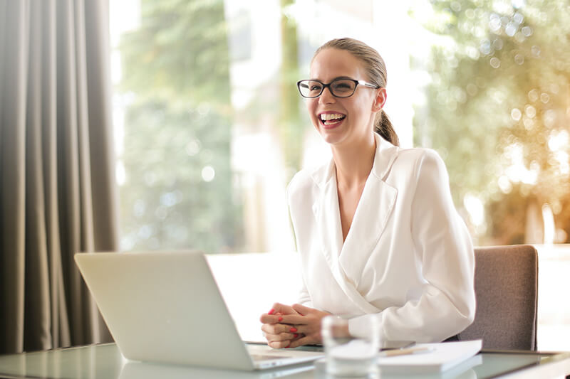 Woman happy after submitting an effective cover letter on her laptop