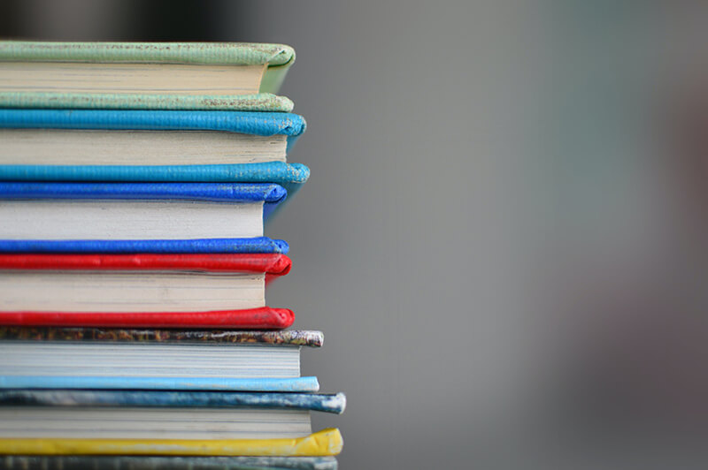 Stack of textbooks and sources for academic research