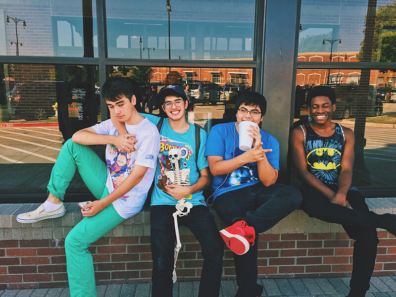 Male friends sitting and laughing together in their high school days