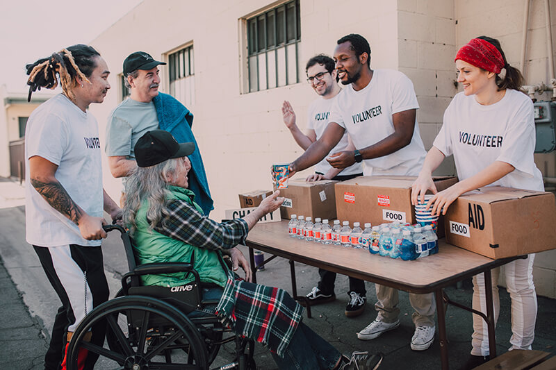 Group of student volunteers making friends while helping others in need