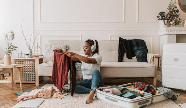 Female student packing for college while following a dorm room checklist