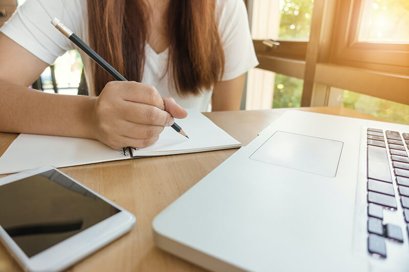 expository essay help Female college student working on a descriptive essay for class