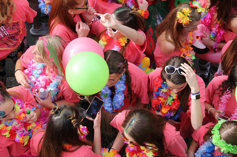 Group of members of a sorority attending an event together and wearing pink shirts