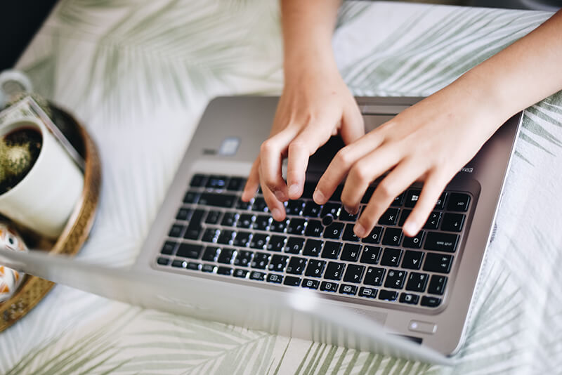 Student working on his essay writing with a closeup of his hands