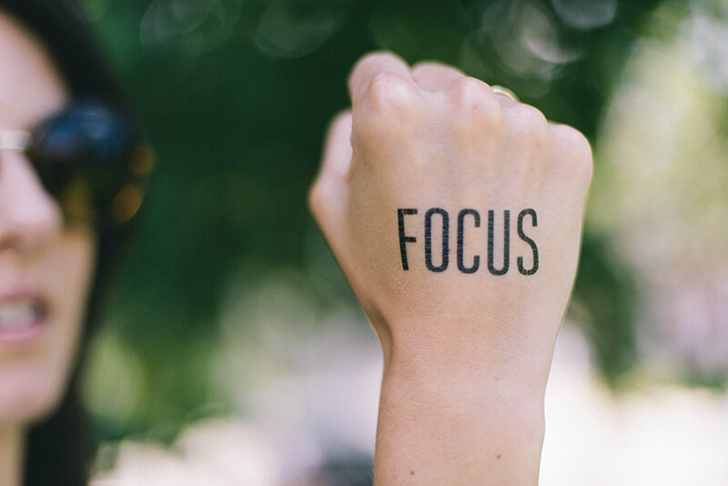 Student with the word focus written on their hand to help them get motivated