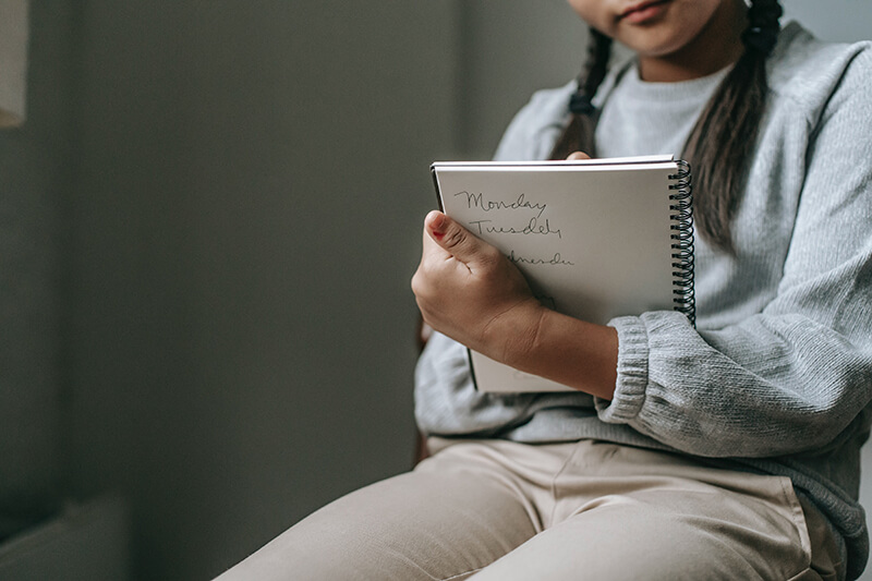 Student holding a notebook to help get motivated during class