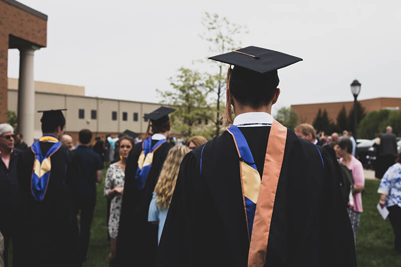 Male college student attending his graduation ceremony after acing his admissions