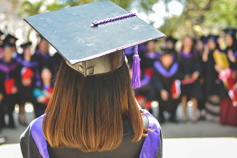 Female graduating after successfully learning how to write a college application essay