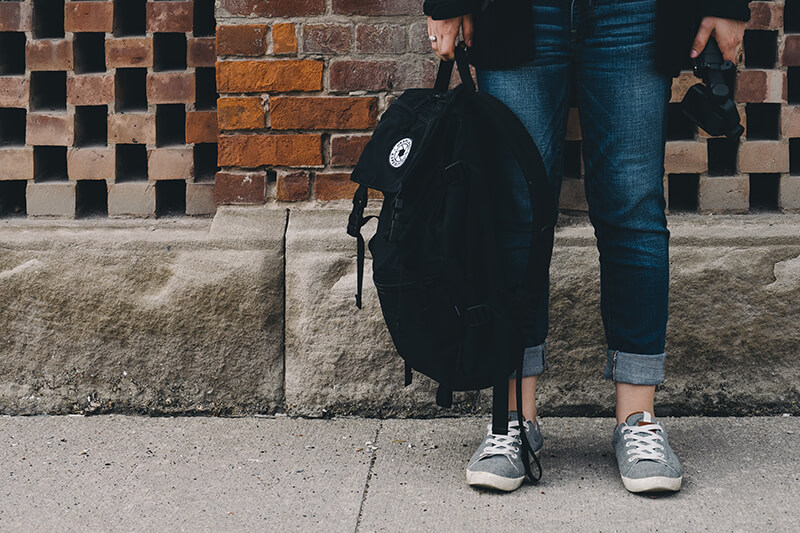 Closeup of feet and backpack of student who was accepted in the admissions process