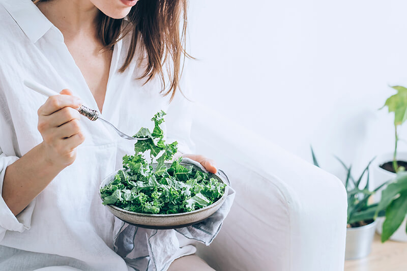 Student eating a kale and green salad before taking exams