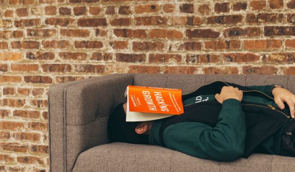 Male Student with senioritis is unable to stay awake while reading a book