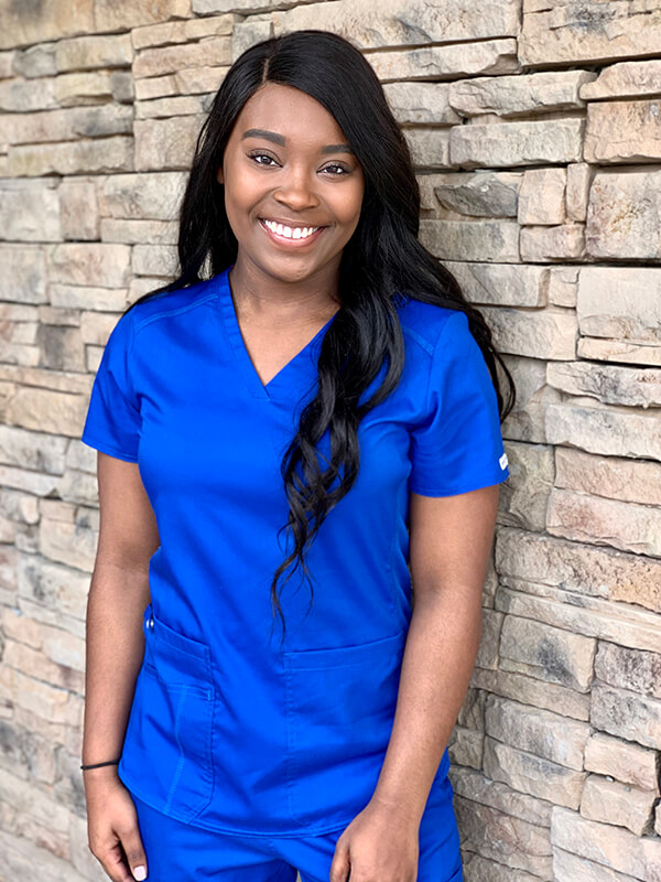 Mykyla Coleman says nursing is a different world and poses in her blue scrubs