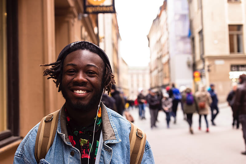 Man smiling amongst a crowd looking happy and motivated